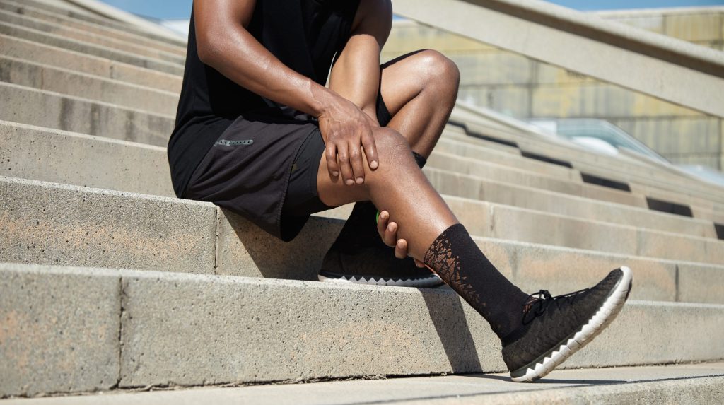 Mann, der sich an sein schmerzendes Knie fasst