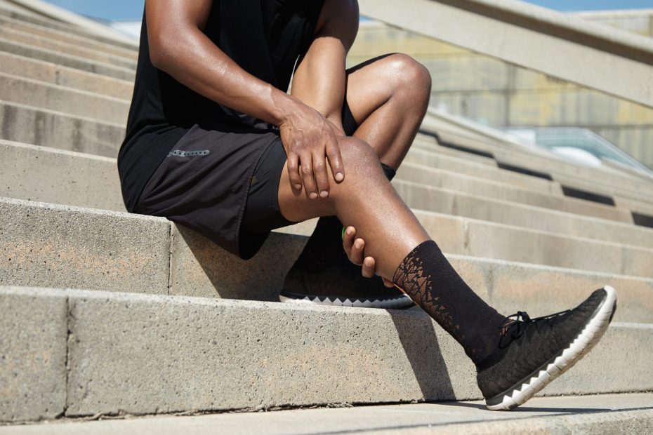 Mann, der sich an sein schmerzendes Knie fasst