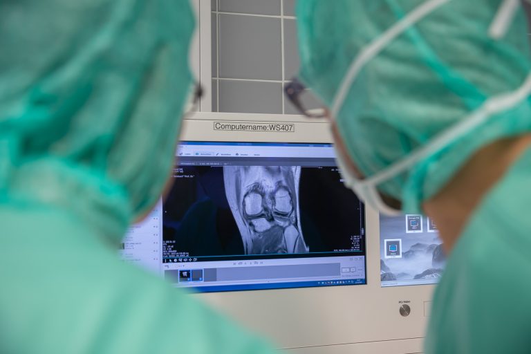 Dr. Martin Gruber sieht auf einen Kniequerschnitt während einer Knie-Operation