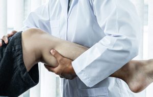 Ein Bein ist abgebildet. Im Unterschenkel wird eine Behandlung nach einer Patellaluxationen durchgeführt.